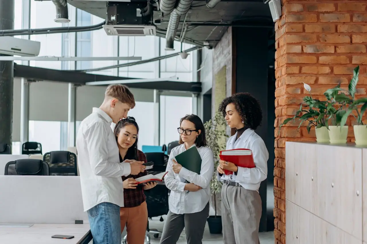 A diverse team of professionals collaborates in a modern office setting, exchanging ideas