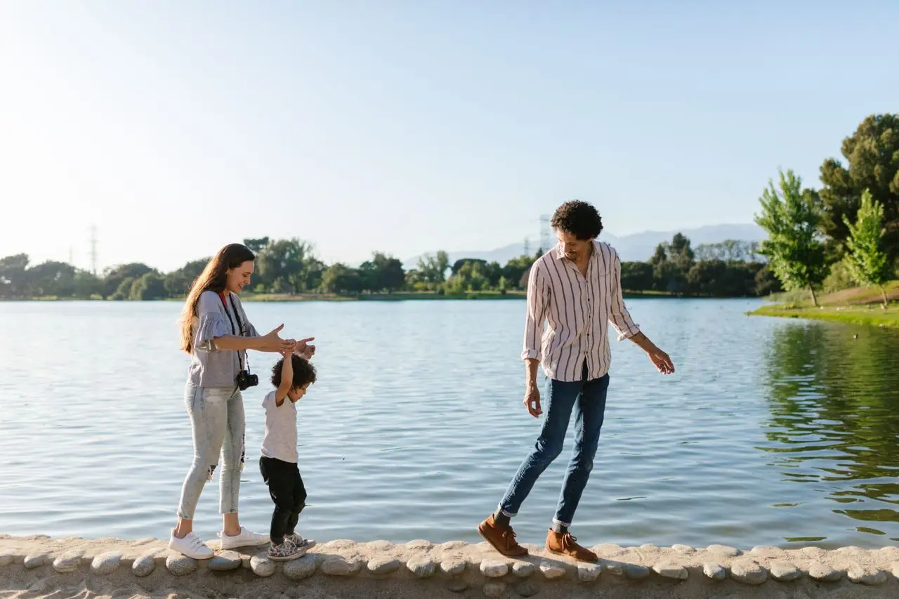 A joyful family enjoying quality time walking by the scenic lake on a sunny day