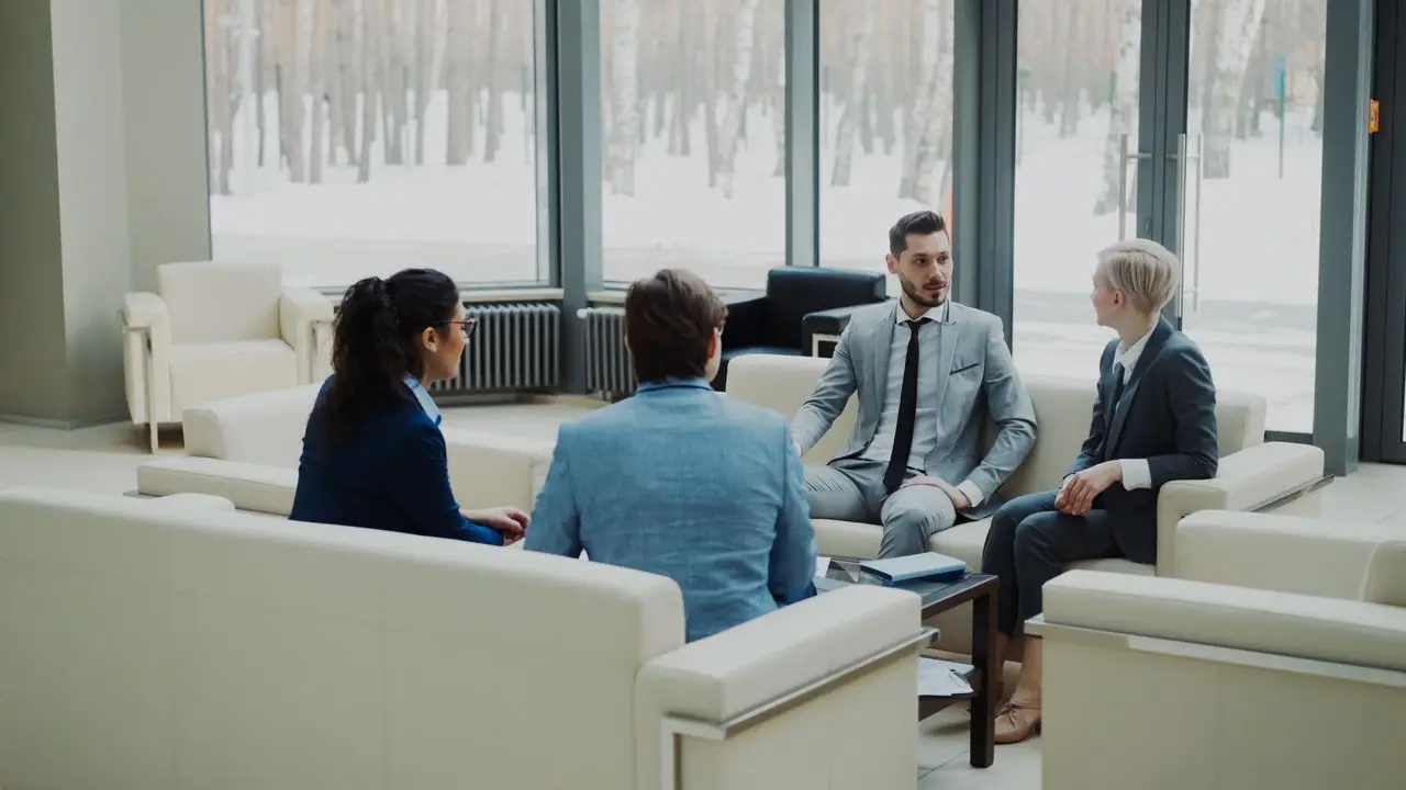 Group of professionals having a discussion in a bright office lounge