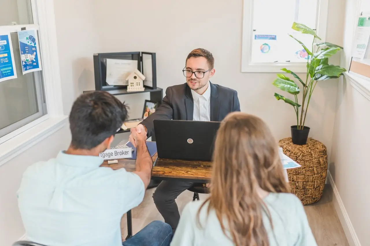 Men and woman discussing mortgage with broker in a modern office setting